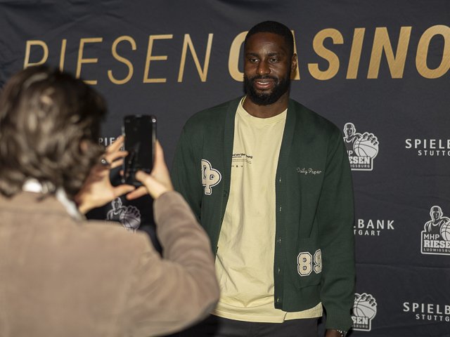 Ein Gast fotografiert einen Spieler an der Fotowand