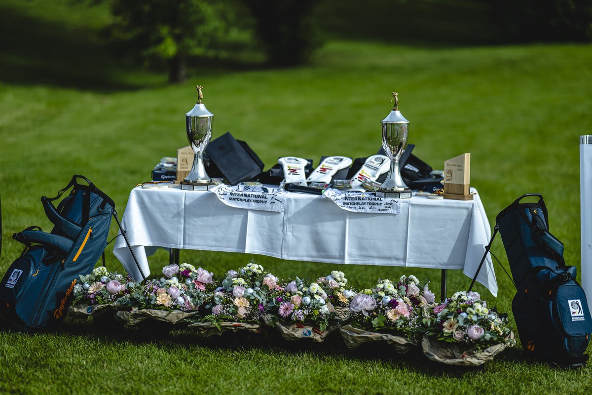 Preistisch mit Pokalen, Golftaschen und Blumen