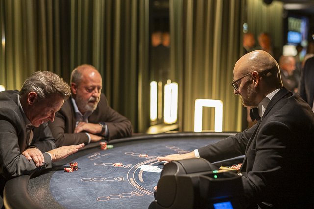 Gäste am Black-Jack-Tisch mit Croupier