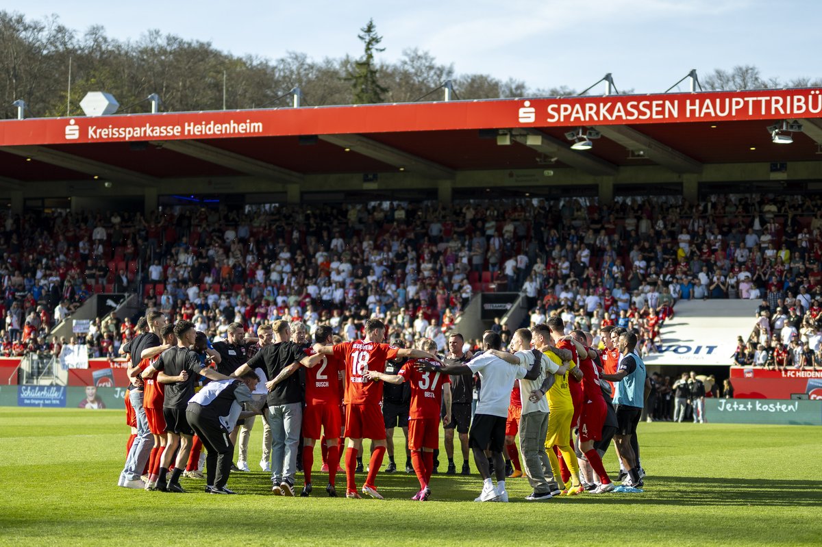 Heidenheimer Mannschaft und Staff im Kreis vor der Haupttribüne